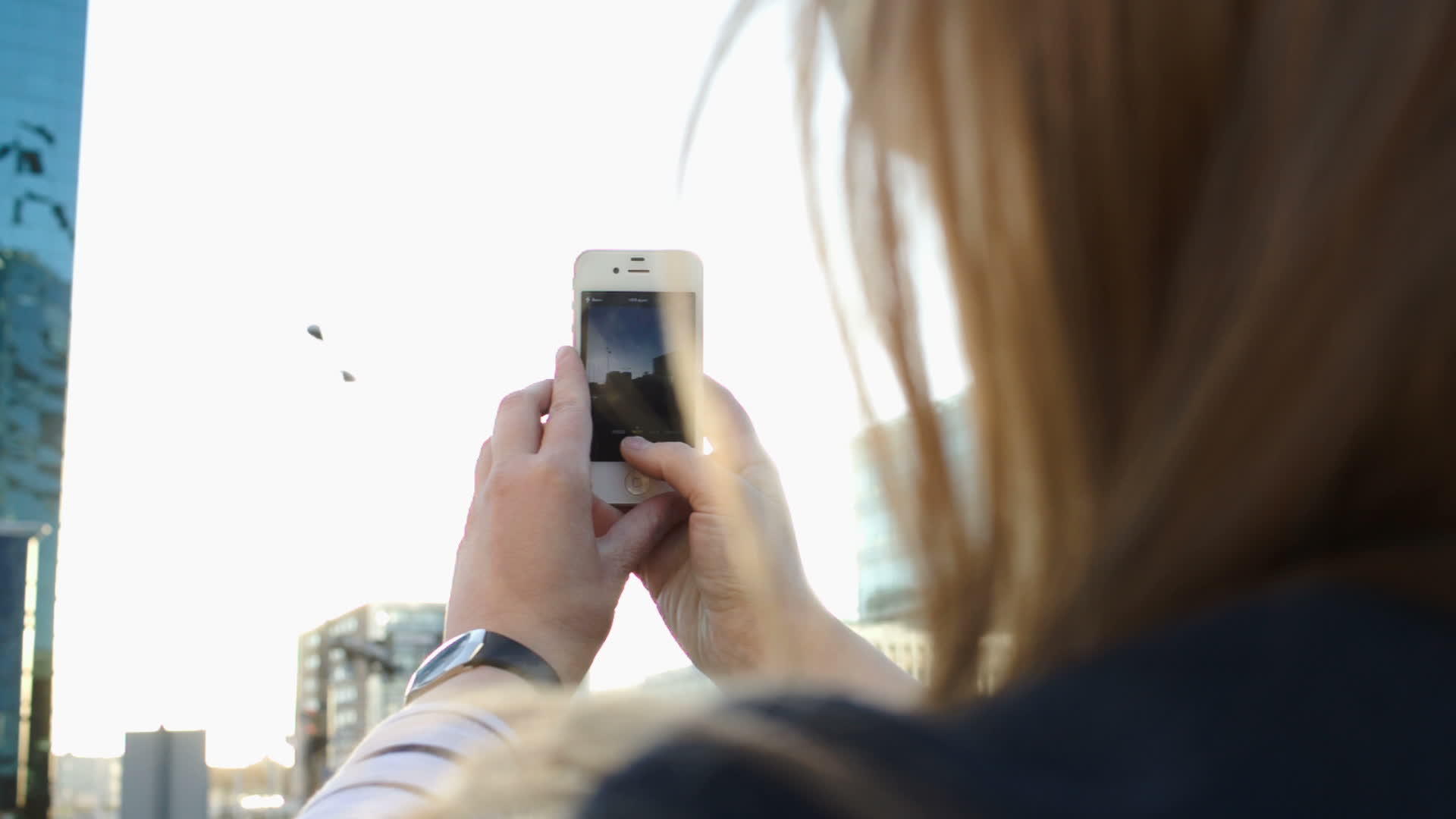 女人用手机拍下城市照片视频的预览图