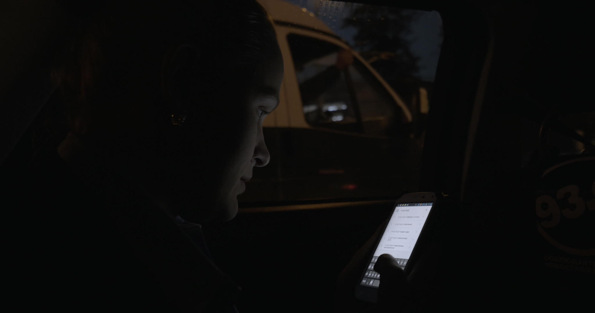 年轻女性在城市夜间乘坐夜车时使用手机视频的预览图