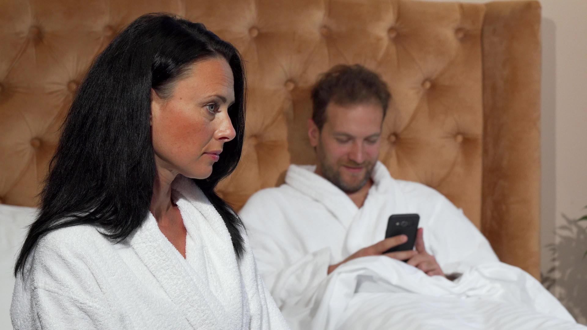 当她丈夫在智能手机上发短信时 成年女性看起来很不开心视频的预览图