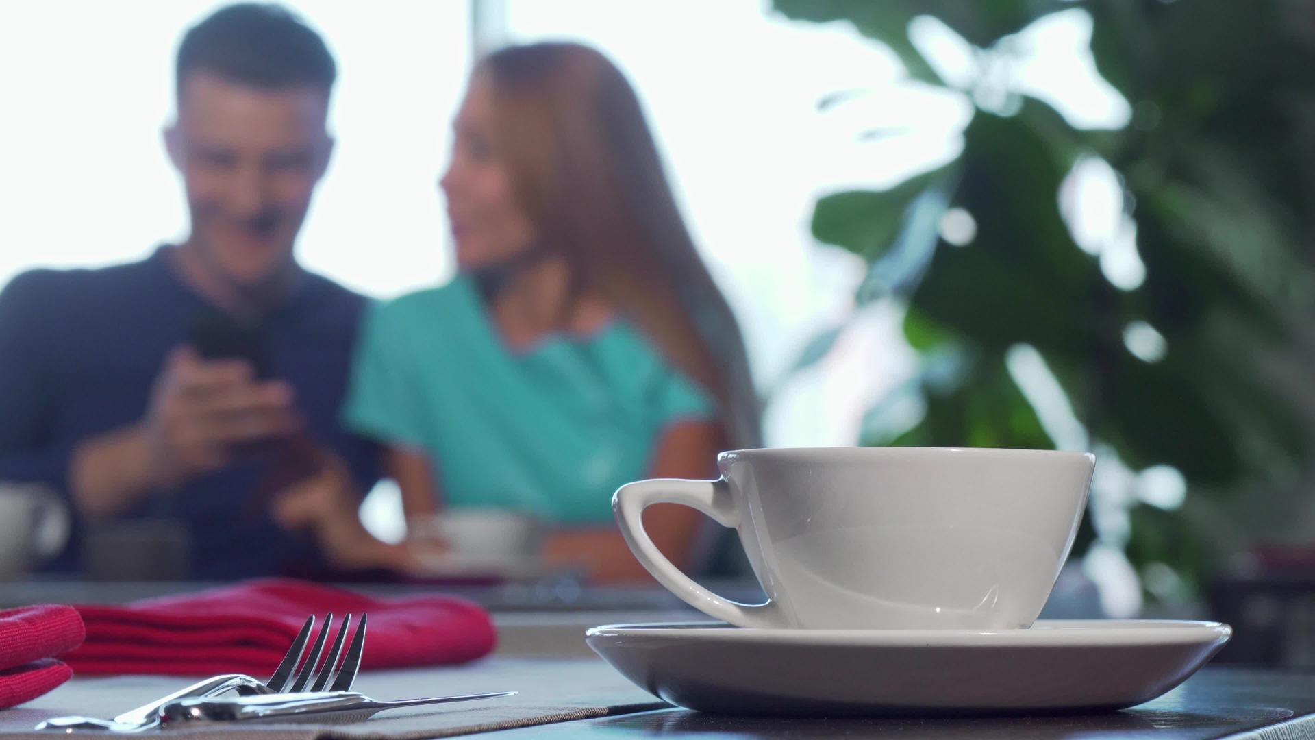 选择性的焦点放在桌子上的杯子上情侣们拥抱背景视频的预览图