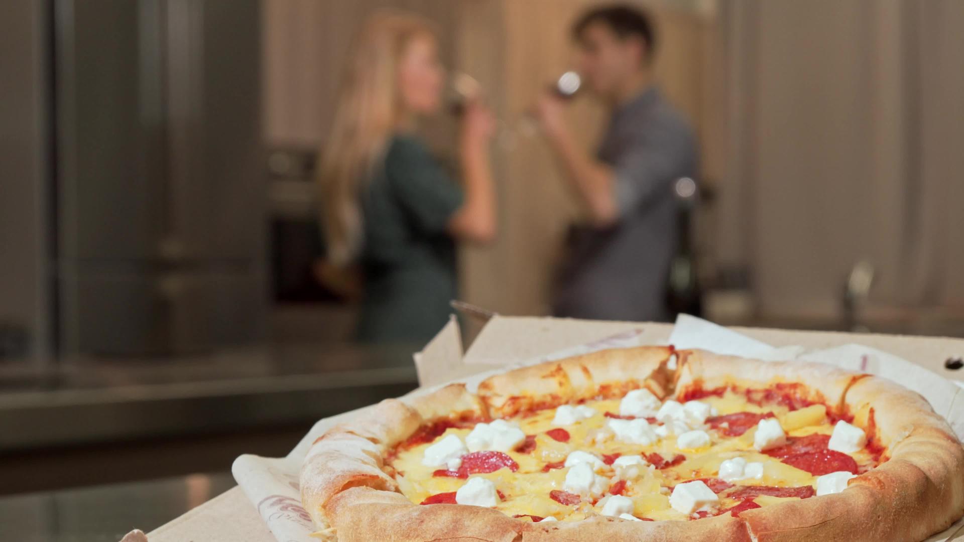 桌上美味的披萨情侣一起喝红酒视频的预览图