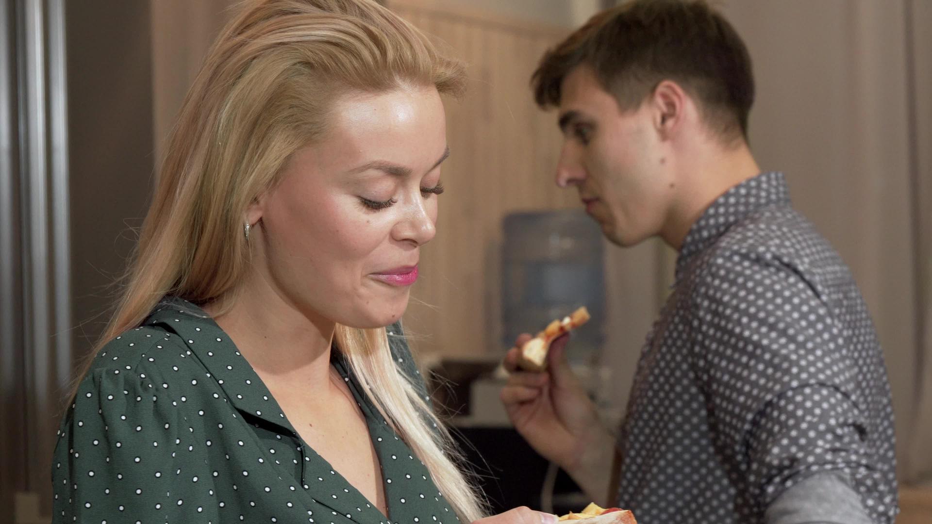 美丽的女人吃着美味的披萨对着男友的相机微笑视频的预览图