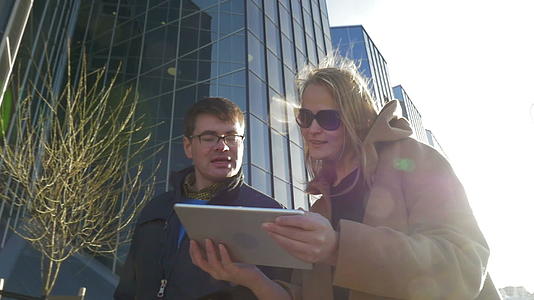 年轻夫妇带着触摸垫在城市里散步视频的预览图