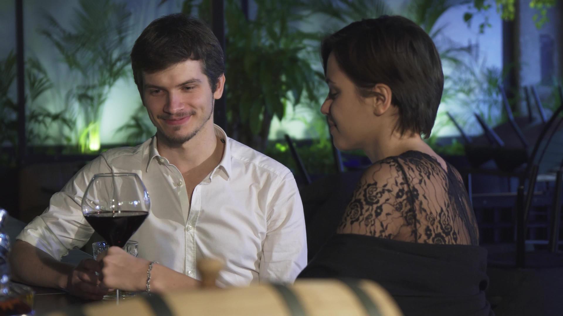 在酒吧里有浪漫约会的年轻夫妇一起喝酒聊天视频的预览图