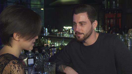 英俊的年轻人在酒吧和漂亮的女朋友聊天视频的预览图