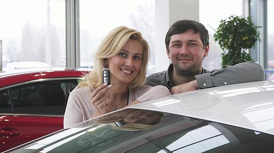 一对美丽成熟的夫妇在他们的新车钥匙旁边视频的预览图