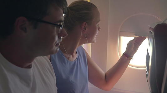 女人和男人看着飞机的窗外视频的预览图
