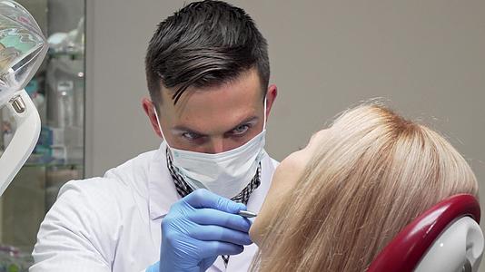 当检查病人的牙齿时微笑着看医生的面具视频的预览图