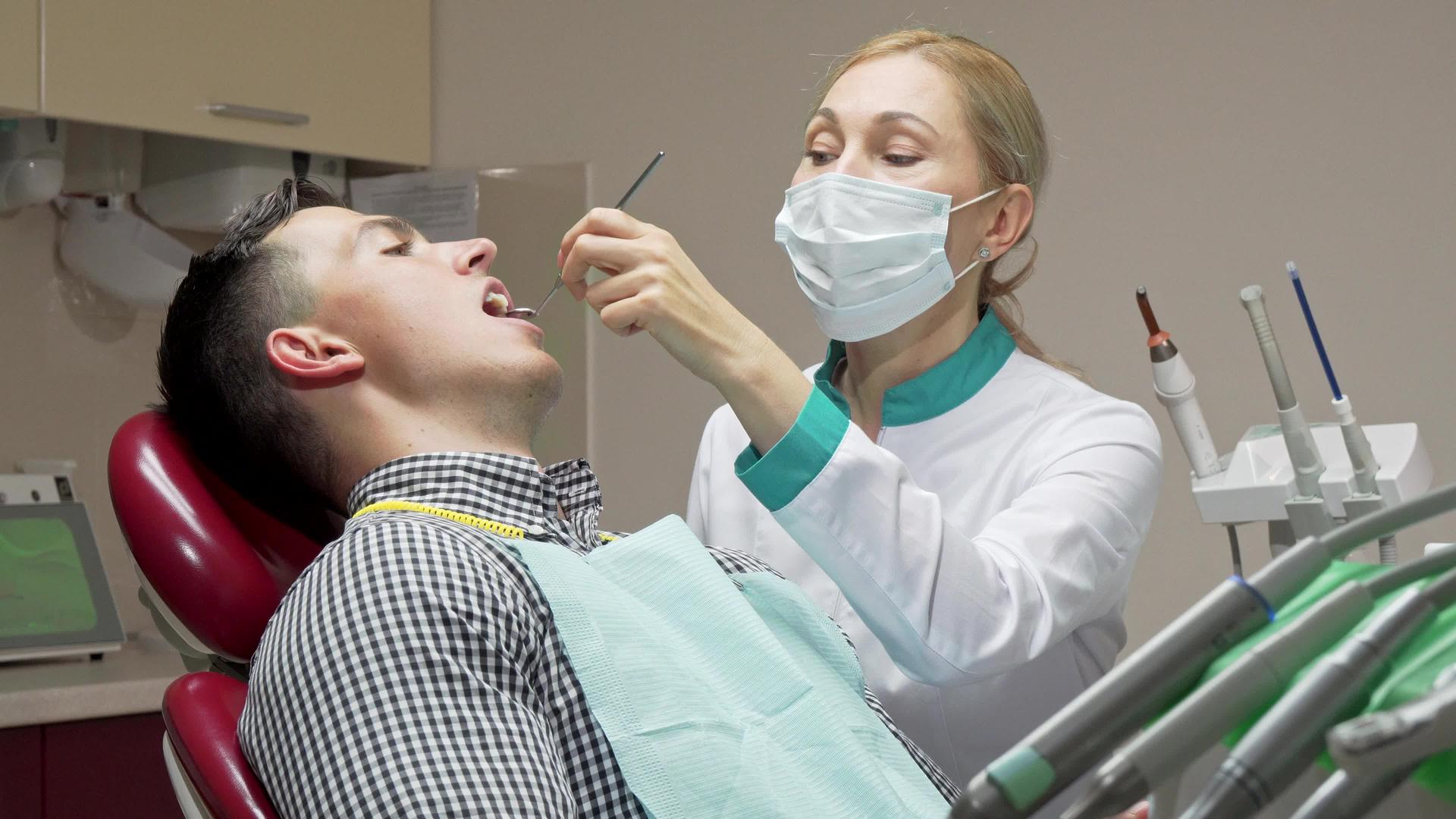 女牙医在牙科诊所检查病人的牙齿视频的预览图
