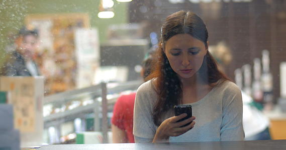 女人在咖啡馆的手机上交换信息视频的预览图