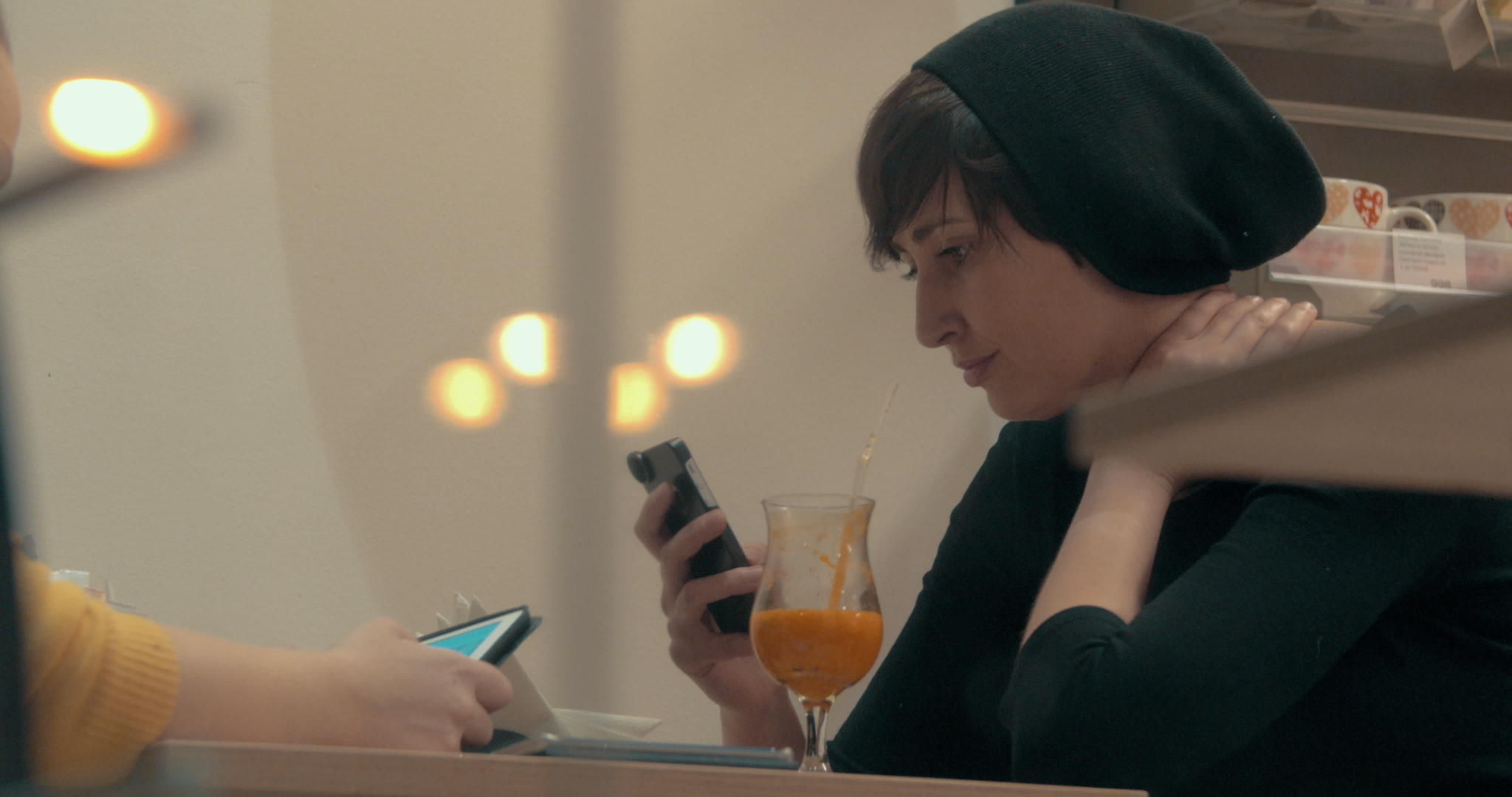 在咖啡馆会议期间女性朋友花时间在手机和床上视频的预览图