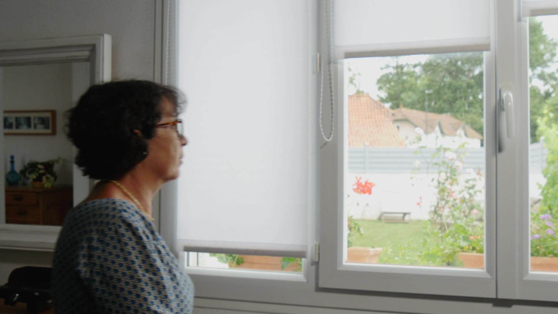 成熟的女人向窗外望去视频的预览图