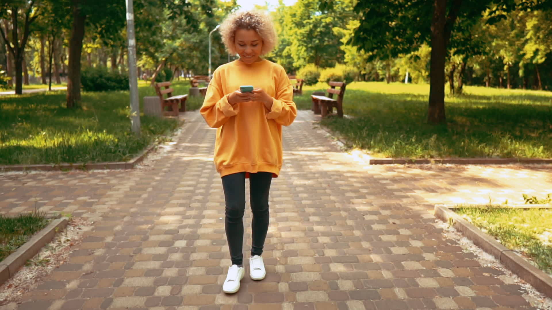 在城市里用智能电话穿黄色毛衣视频的预览图