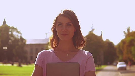 学生肖像照片用电脑在户外行走视频的预览图