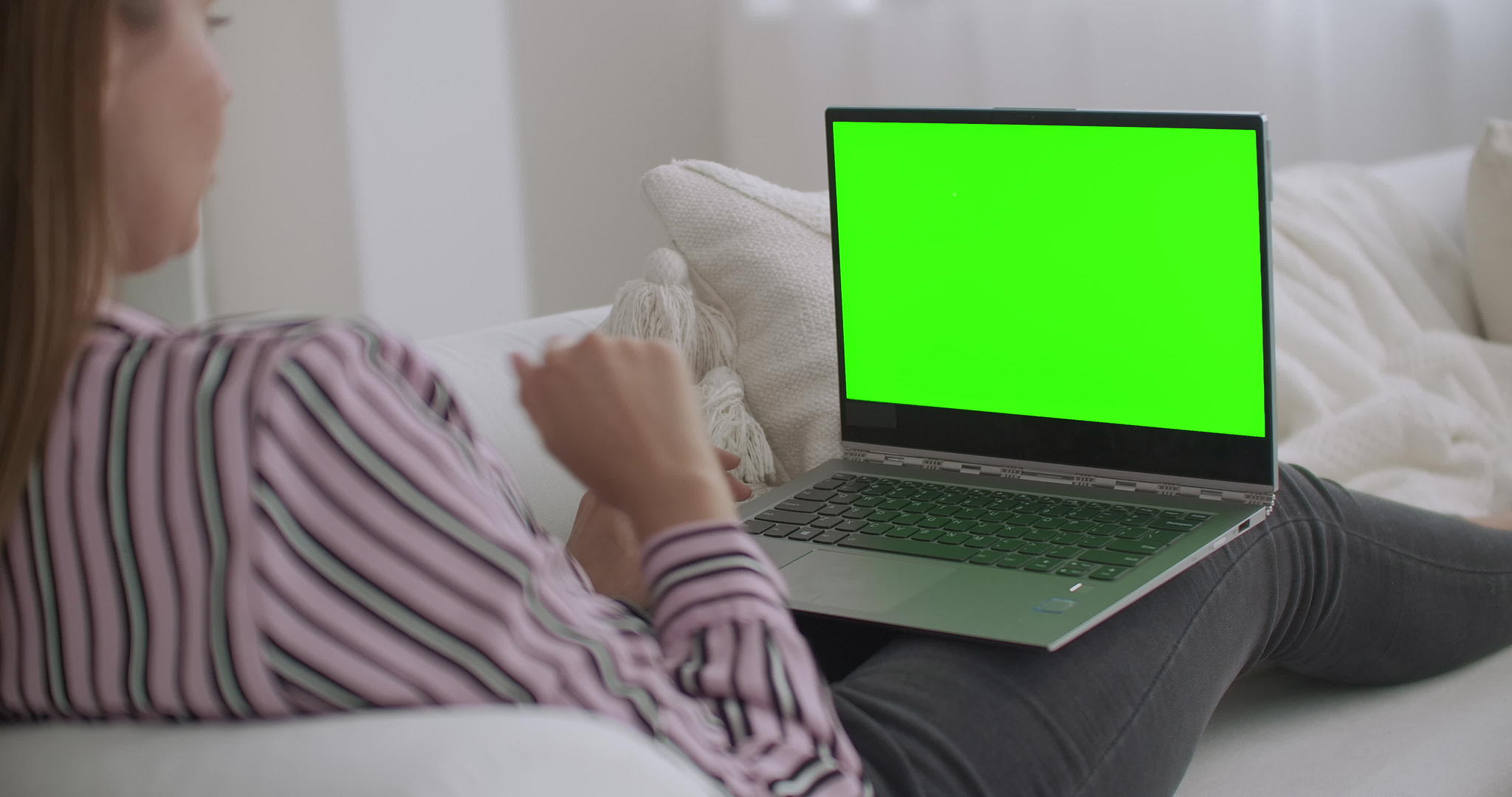 年轻和放松的女性使用带有绿色屏幕的笔记本电脑进行色度视频的预览图