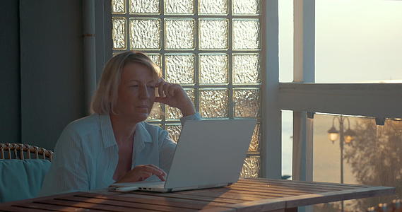 阳台上有笔记本电脑的成年女性视频的预览图