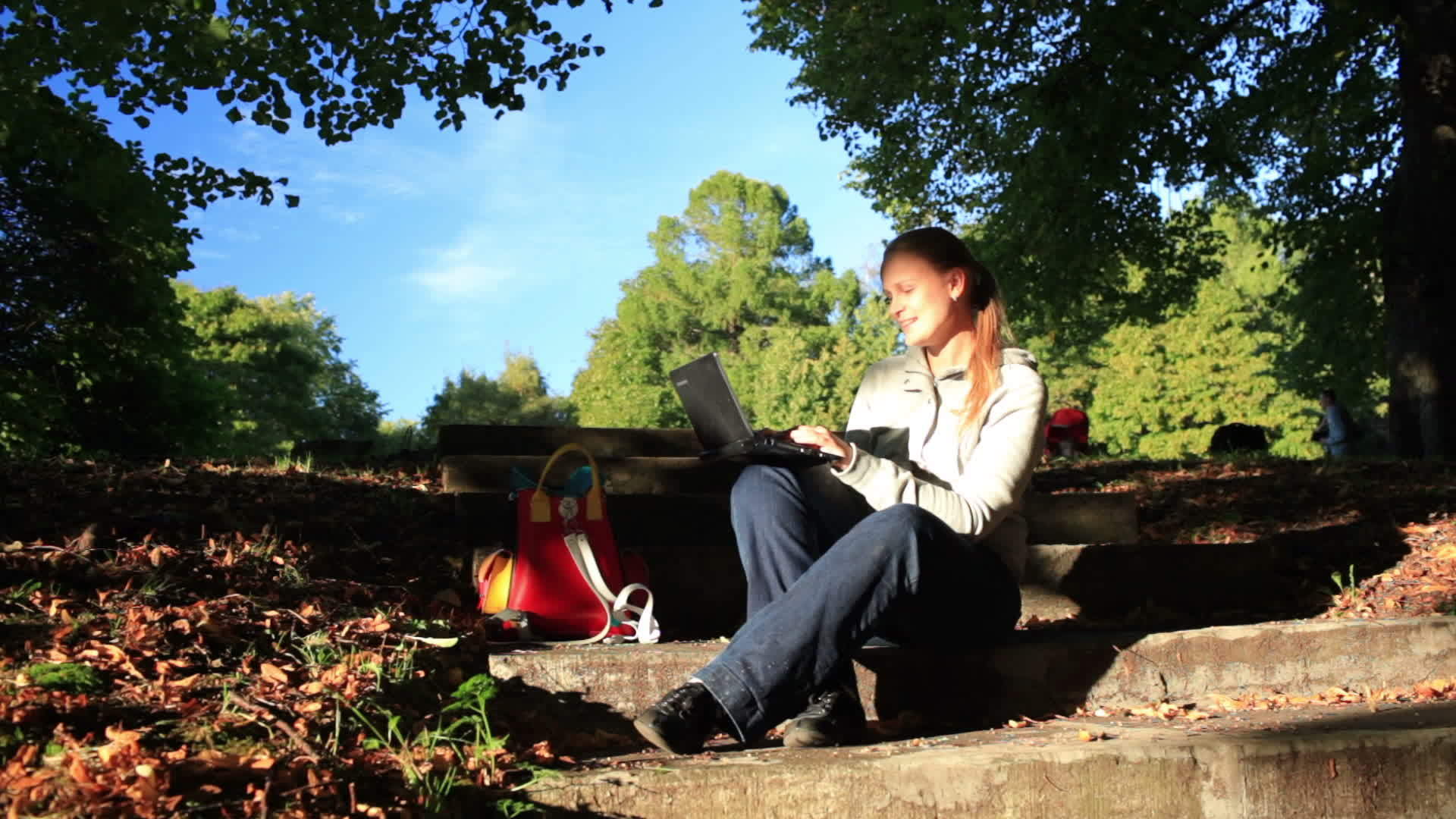 年轻女性使用笔记本电脑在户外工作视频的预览图