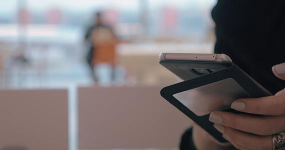 在机场咖啡馆使用手机的妇女视频的预览图