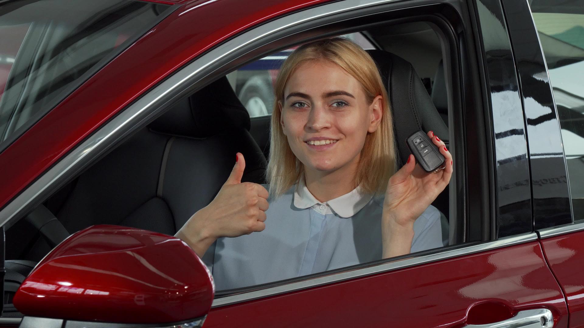 快乐的女司机展示了她的车钥匙和拇指视频的预览图