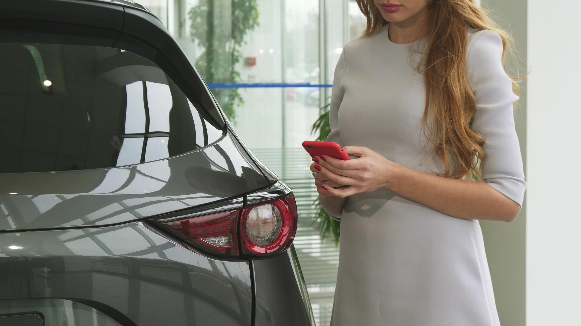 汽车经销商用智能手机拍摄了一名妇女的照片视频的预览图