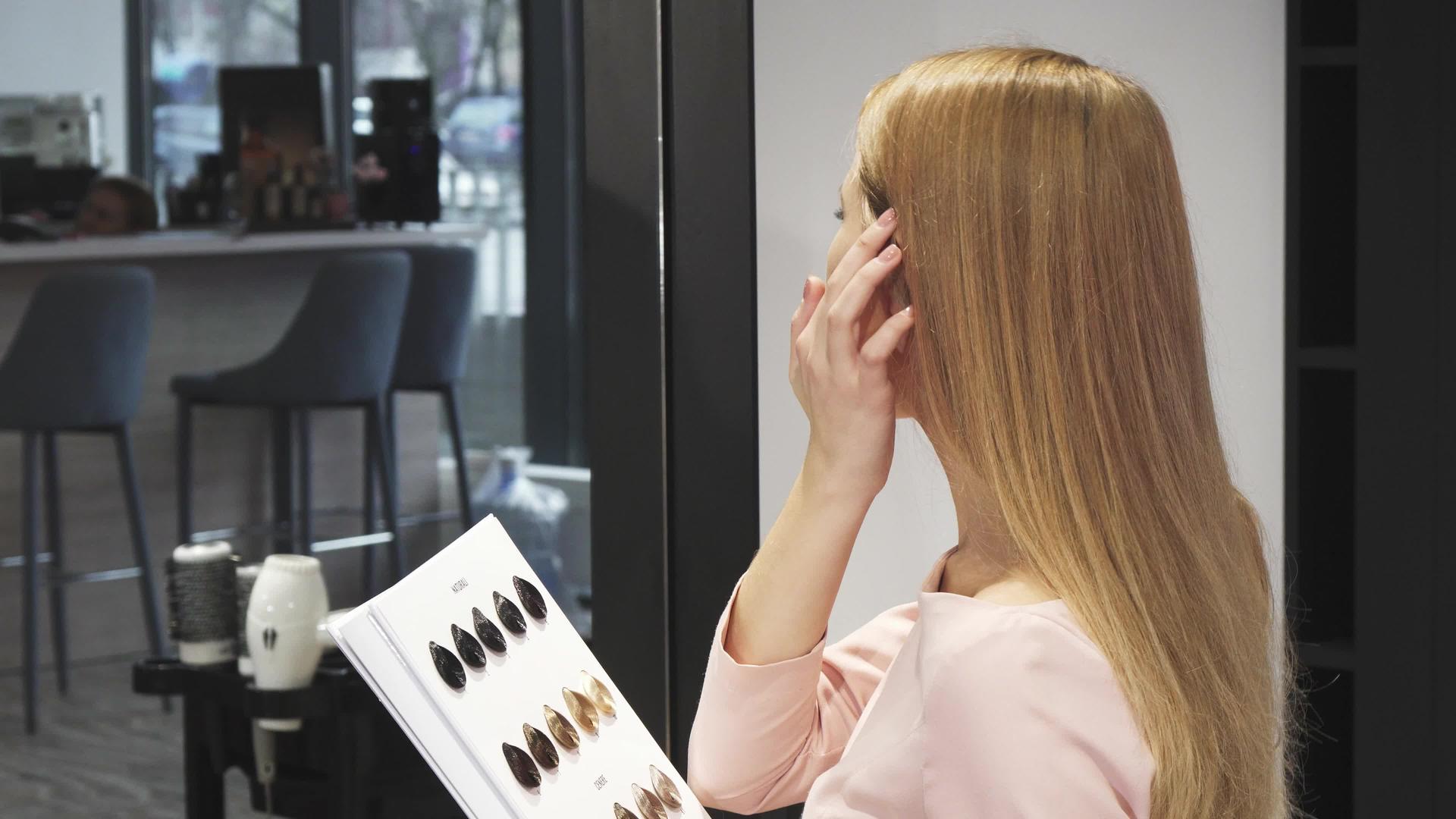 快乐美丽的女人用拇指坐在美发师工作室视频的预览图