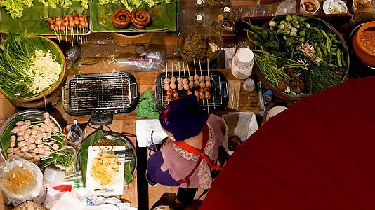在亚洲食品广场出售食品的匿名女性面目全非的女性卖家视频的预览图