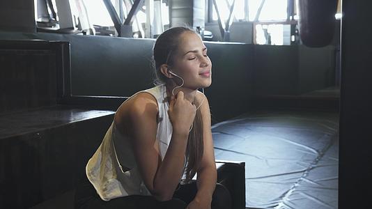 快乐性感的年轻健身女性在健身房享受音乐视频的预览图