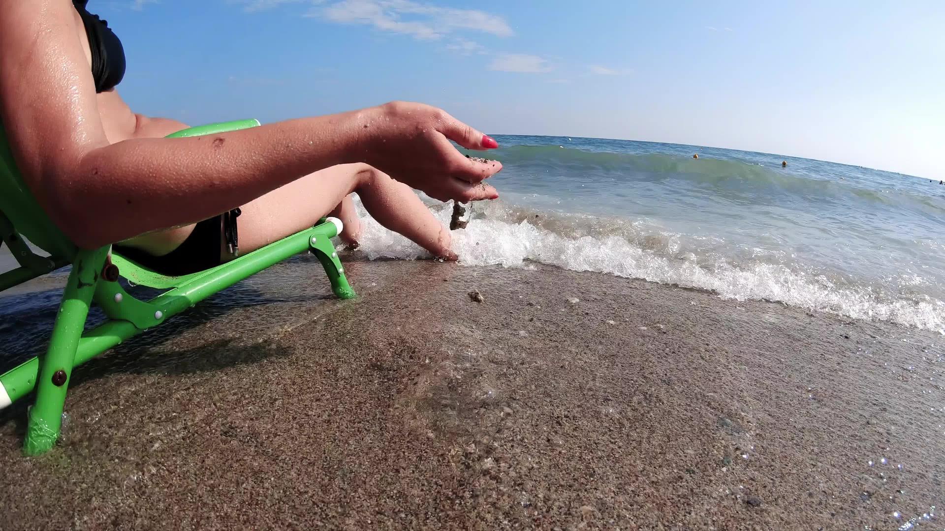 女人们坐在海边玩沙子放松坐在海边度假视频的预览图