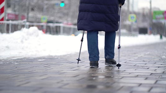活跃的老年妇女用登山杖训练北欧步行 冬天在户外练习视频的预览图