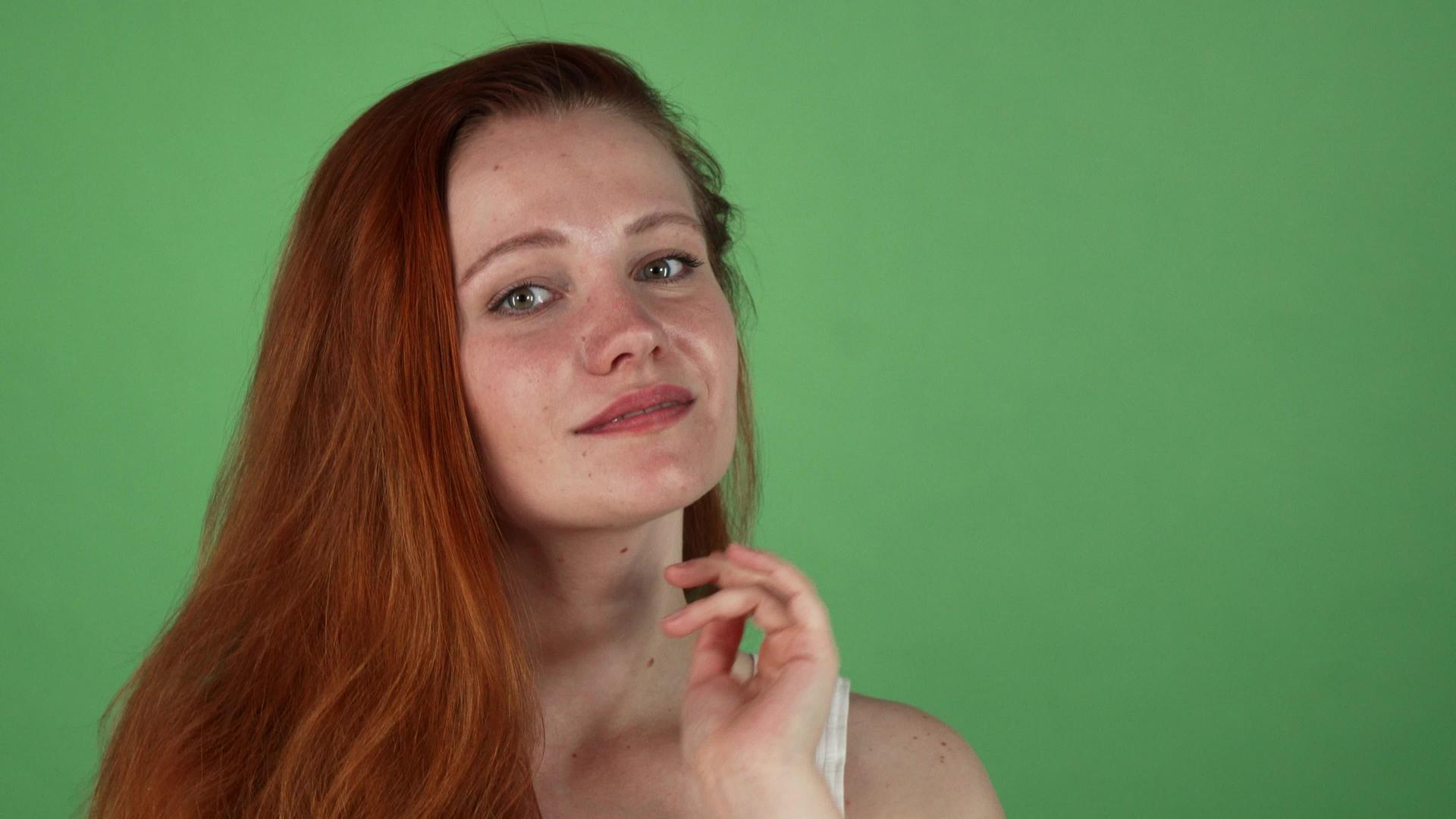 长长的姜头发绿色背景的漂亮女人视频的预览图