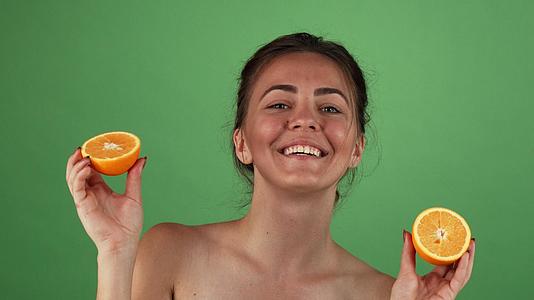 美丽快乐的女美人微笑着拿着橙色的绿色染色体视频的预览图