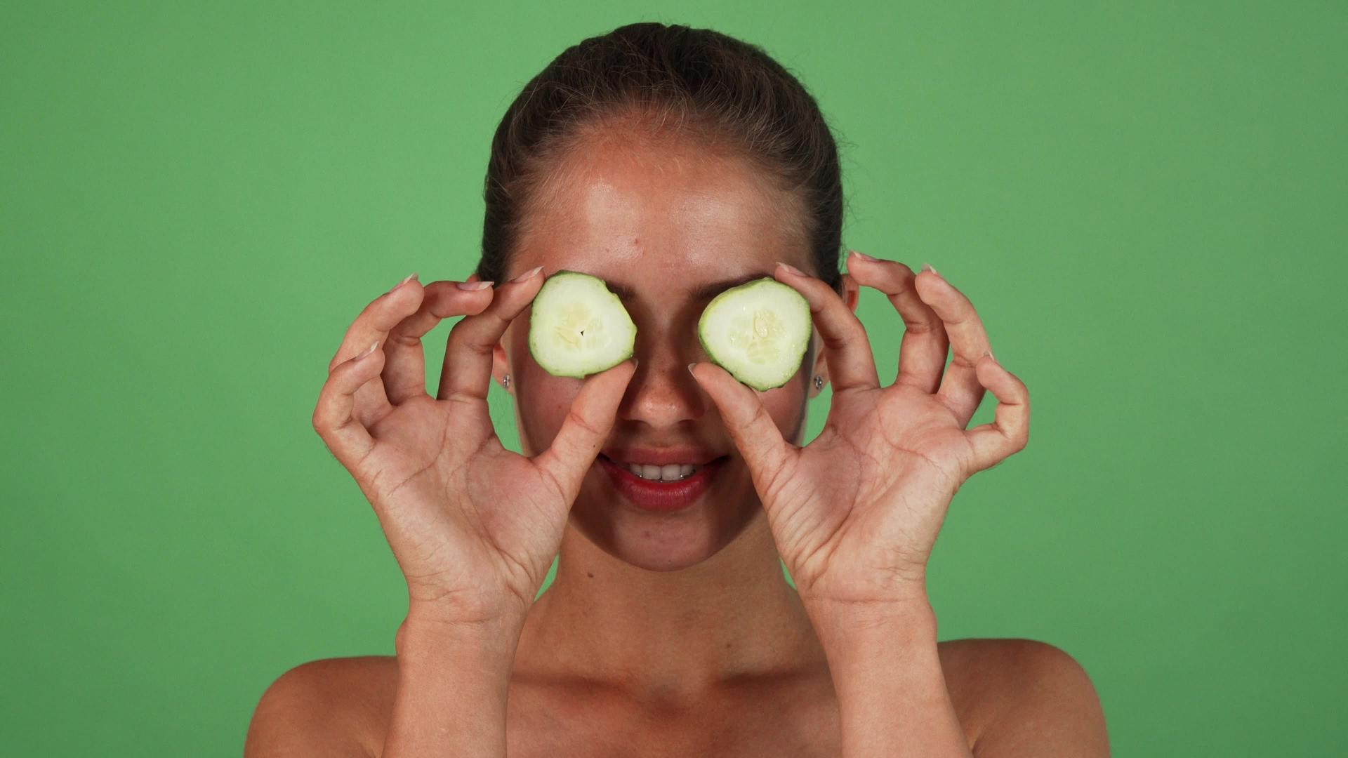 一个快乐健康的女人用黄瓜片遮住她的眼睛视频的预览图