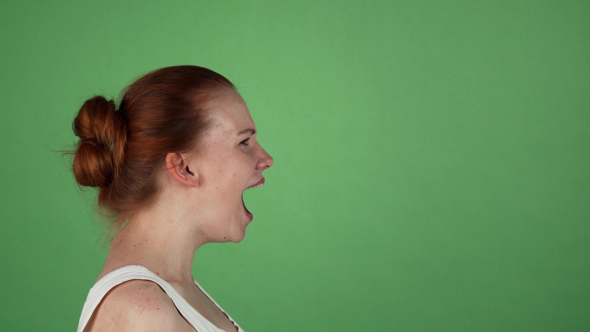 年轻女孩在绿色染色体背景上尖叫视频的预览图