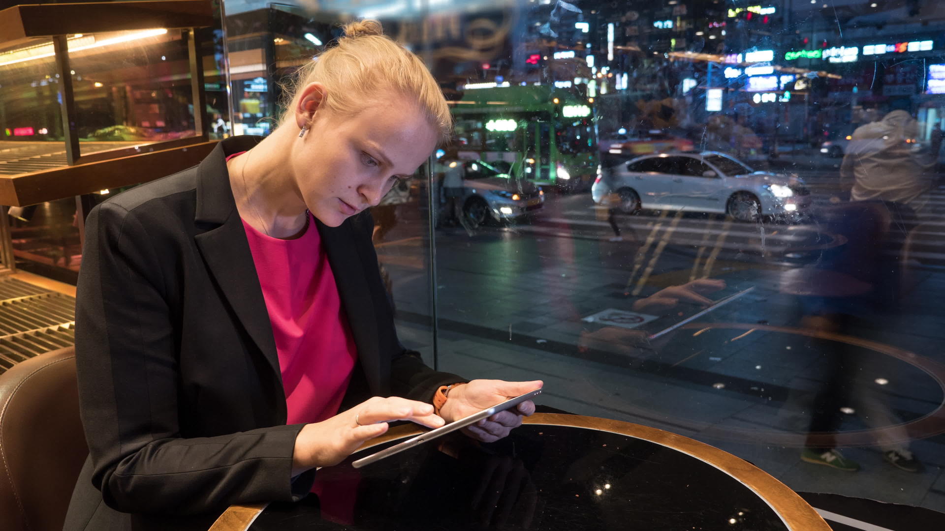 在韩国首尔的城市背景中女性使用触摸板坐在咖啡馆里视频的预览图