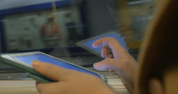 地铁乘客手中的平板电脑视频的预览图