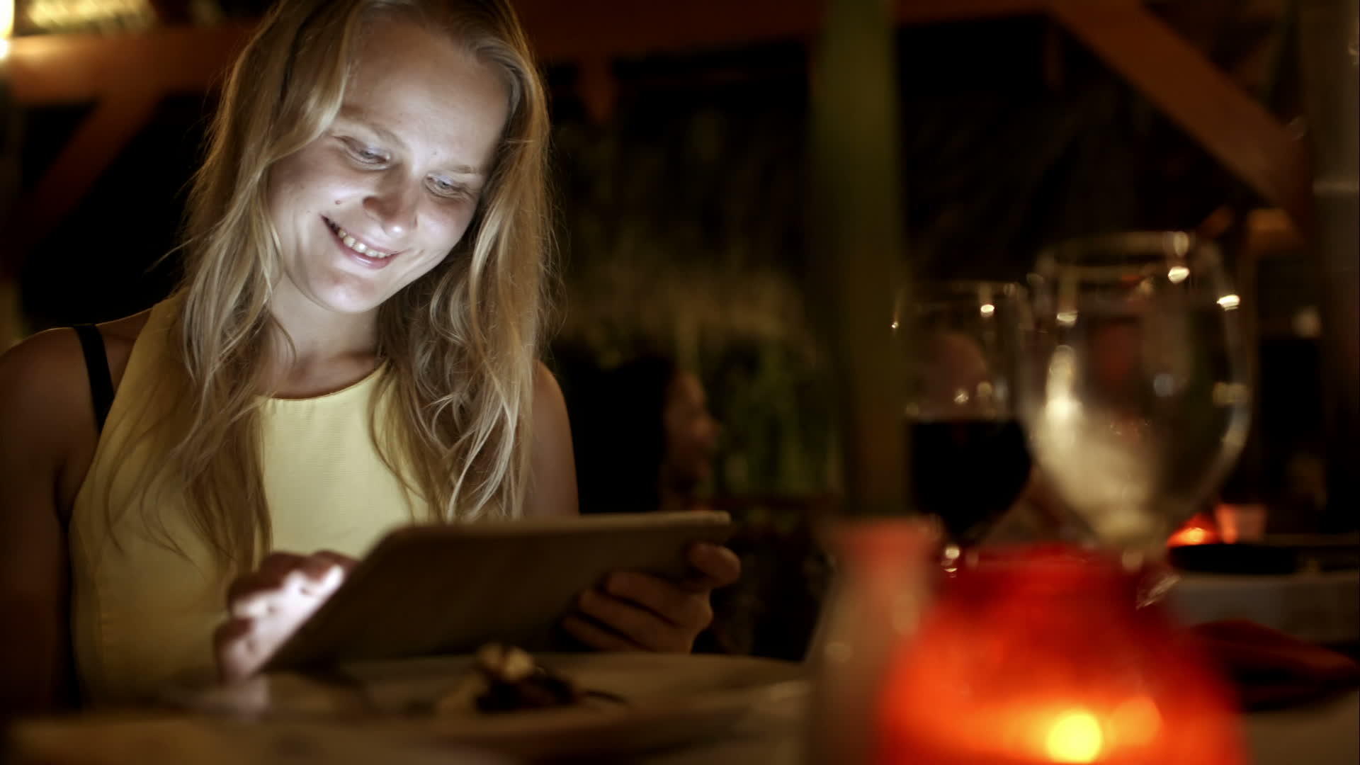 女性在度假期间在餐馆使用平板电脑视频的预览图