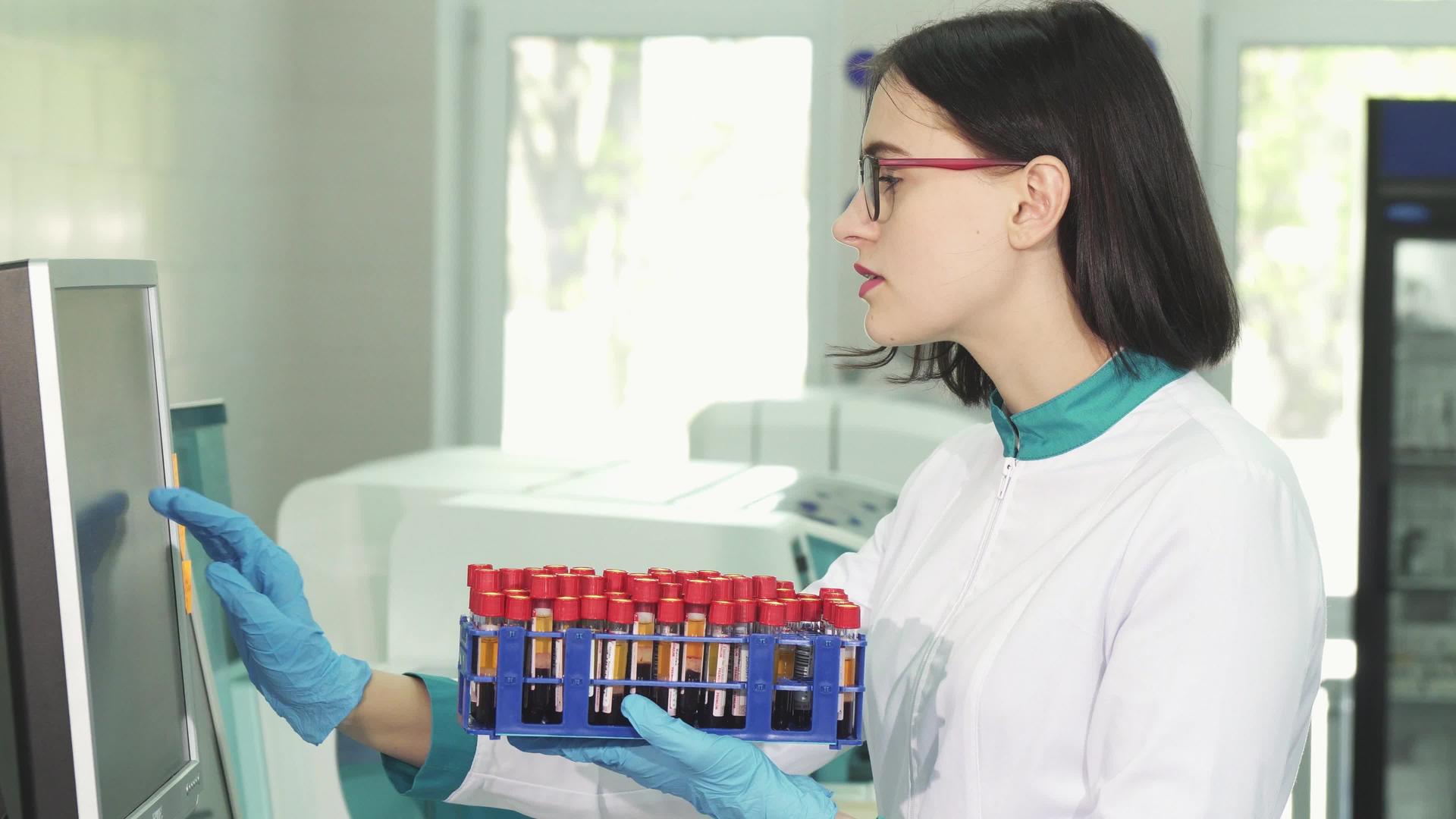 年轻女性科学家用血液样本检查测试管视频的预览图