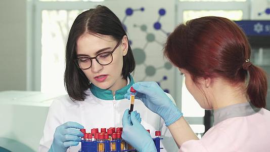 一位有魅力的女性化学家和她的助手从事测试管理工作视频的预览图