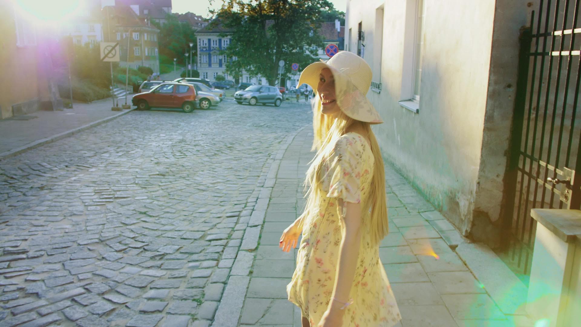 走在城镇街道上的女人微笑的女孩走在老城区的街道上视频的预览图