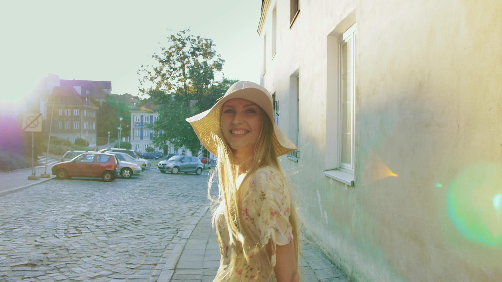 走在城镇街道上的女孩微笑的女人走在老城区的街道上视频的预览图
