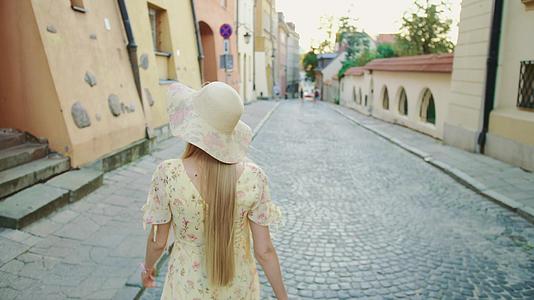 一个戴着白帽子的漂亮女孩走在城市里看着镜头笑得要死视频的预览图