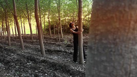 女人在大自然中享受春天的树木和日落的阳光视频的预览图