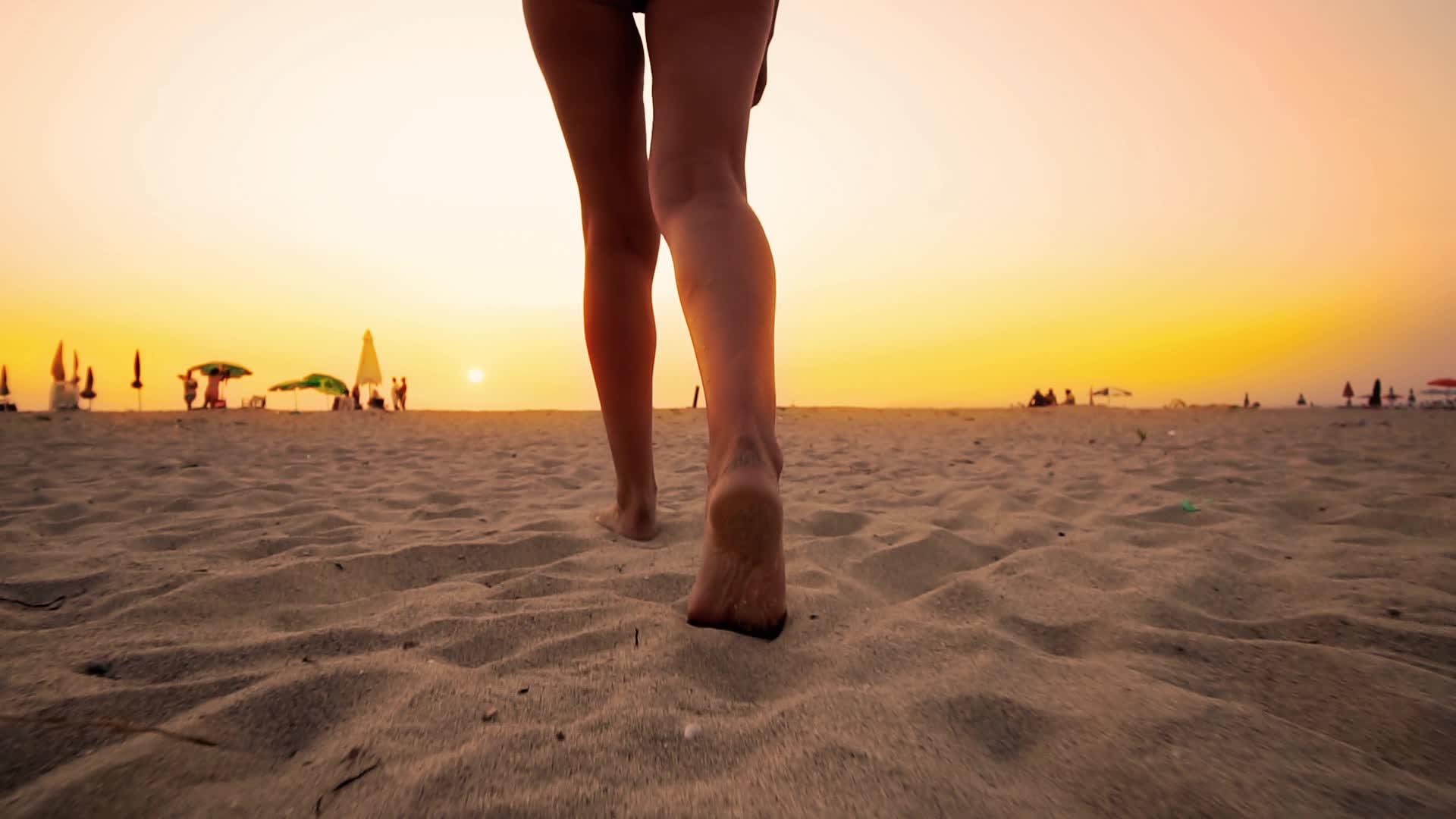 日落时走在热带海滩上的妇女视频的预览图