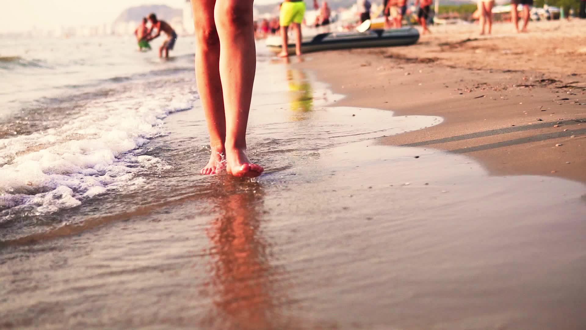 日落时女人们沿着海边慢慢地走着视频的预览图