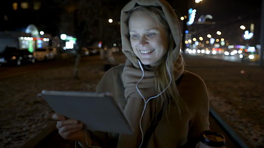 快乐的女人晚上带着床垫在城市里走来走去视频的预览图