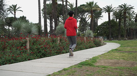 女人在公园后面的风景中慢跑视频的预览图