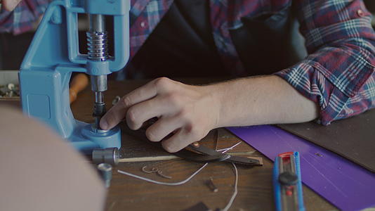 皮革制造商将金属按钮插入腰带视频的预览图