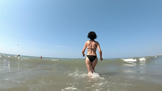 女人在浅水海滩上慢跑视频的预览图