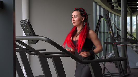 女子跑步机健身房运动员慢跑室内减肥运动慢跑有氧运动视频的预览图