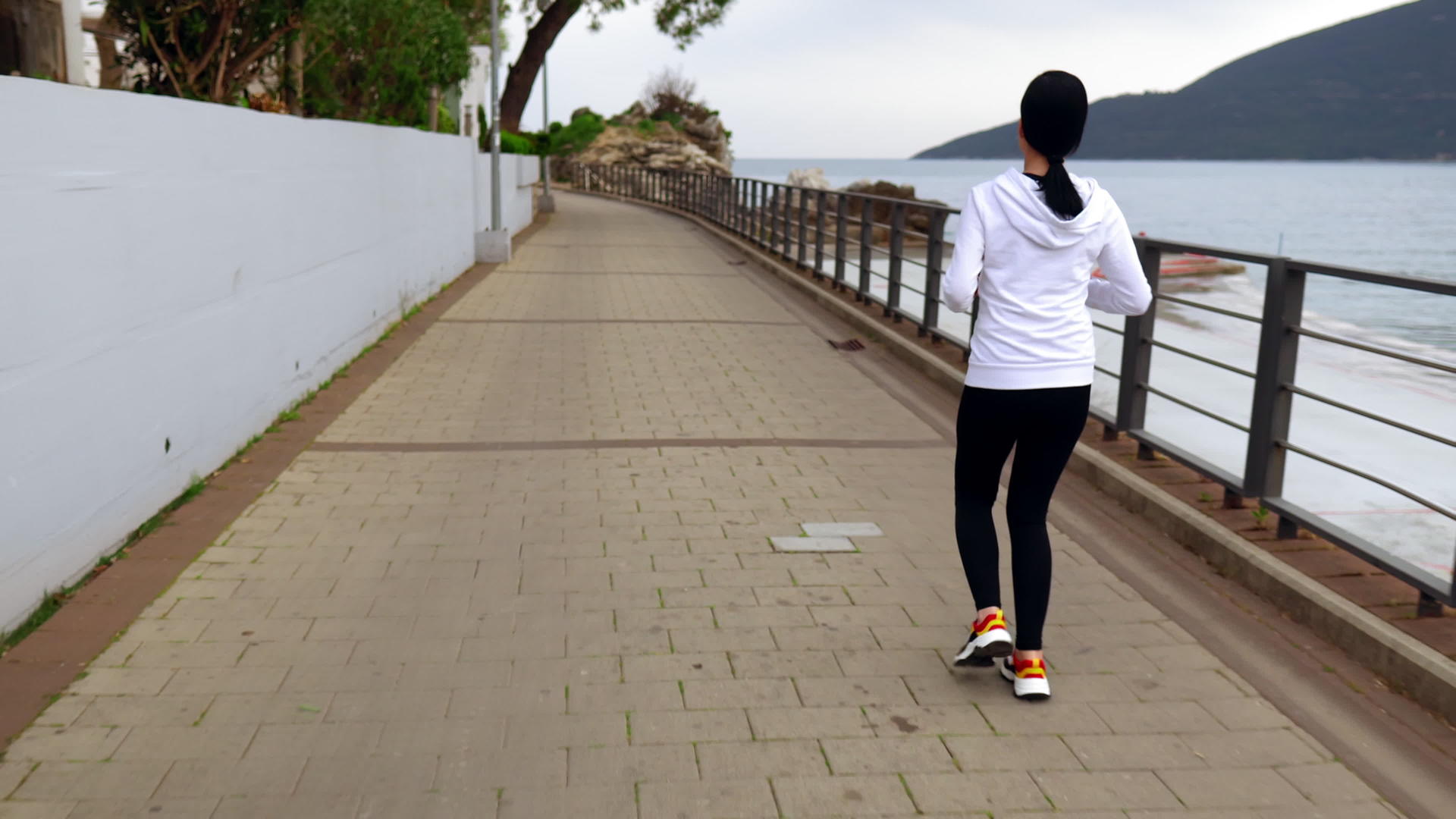 妇女骑着4k在海边慢跑的视频视频的预览图